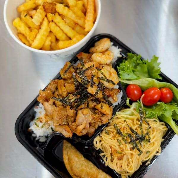 Takeout bento box with chicken, shrimp, noodles, salad, dumpling, and a cup of fries.